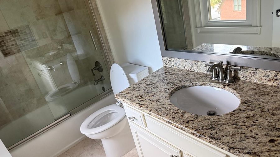 Bathroom with toilet, granite vanity sink and tub-shower fixtures